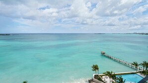 A resort with a pool, palm trees, and a pier extending into turquoise waters. - Aqualina 1001 in Nassau (Nassau)