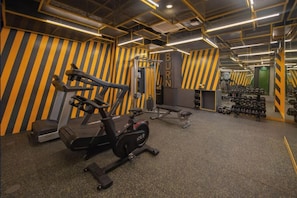 A gym with exercise equipment, including a treadmill, stationary bike, and weight bench.