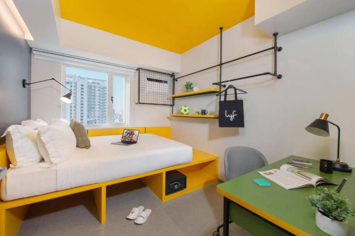 A compact room with a bed, a desk, and a window.
