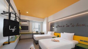 A hotel room with two beds, a desk, a TV, and a wall with a motivational quote. - Lyf Malate Manila by Ascott (Manila)
