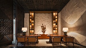Um hall de entrada com balcão de atendimento central, área de estar e painéis decorativos na parede.