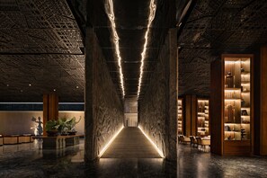 Een modern interieur met een centrale doorgang, houten kolommen en sfeerverlichting.