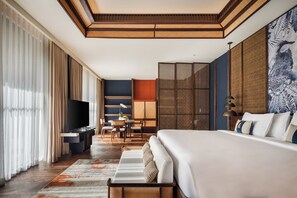 Hotelkamer met een groot bed, een flatscreen televisie, een zithoek en uitzicht op de omgeving.