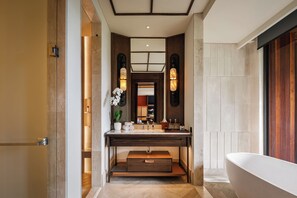 Une salle de bain moderne avec une baignoire sur pieds, un meuble-lavabo avec un miroir et un petit lavabo.