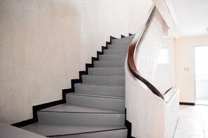 A staircase with a handrail and a textured wall. - Victoria Mansions By Zuzu (Manila)