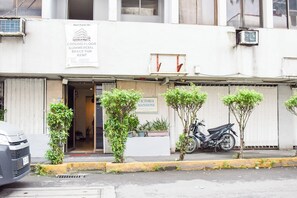 A commercial building with a ground floor for rent, a sign for Ictoria Mansions, and a parked motorcycle. - Victoria Mansions By Zuzu (Manila)