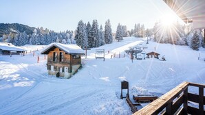 A snow-covered ski resort with a wooden cabin, ski lift, and a clear sky. - Residence Le Grand Morillon (Morillon)