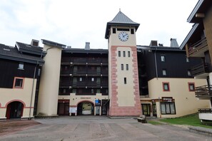 A building with a clock tower, multiple balconies, and a sign for 'Le Grand Morillon.'