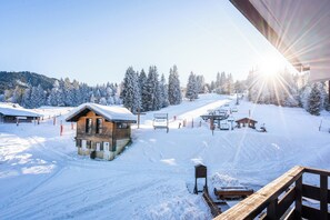 A snow-covered ski resort with a wooden cabin, ski lift, and a clear sky. - Residence Le Grand Morillon (Morillon)