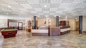 A spacious lobby with a pool table, reception desk, and a modern ceiling design. - Residence Le Grand Morillon (Morillon)