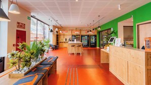 Ein modernes Interieur mit einer Rezeption, einer Sitzecke und Verkaufsautomaten.