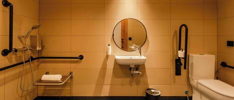 Un baño moderno con lavabo, espejo, inodoro y ducha.