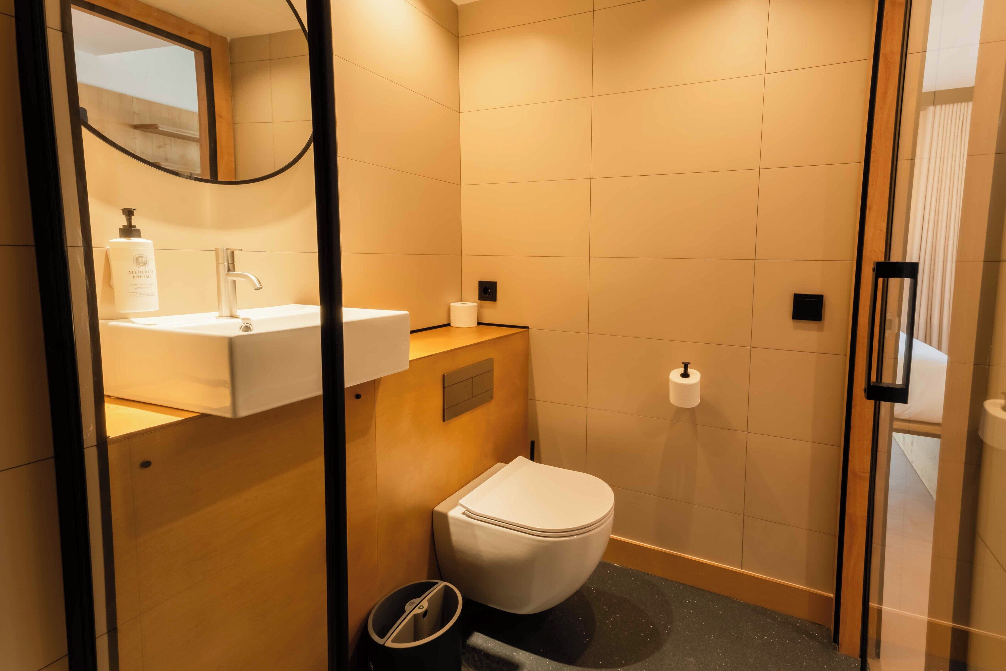 Un baño moderno con lavamanos, inodoro y zona de ducha.