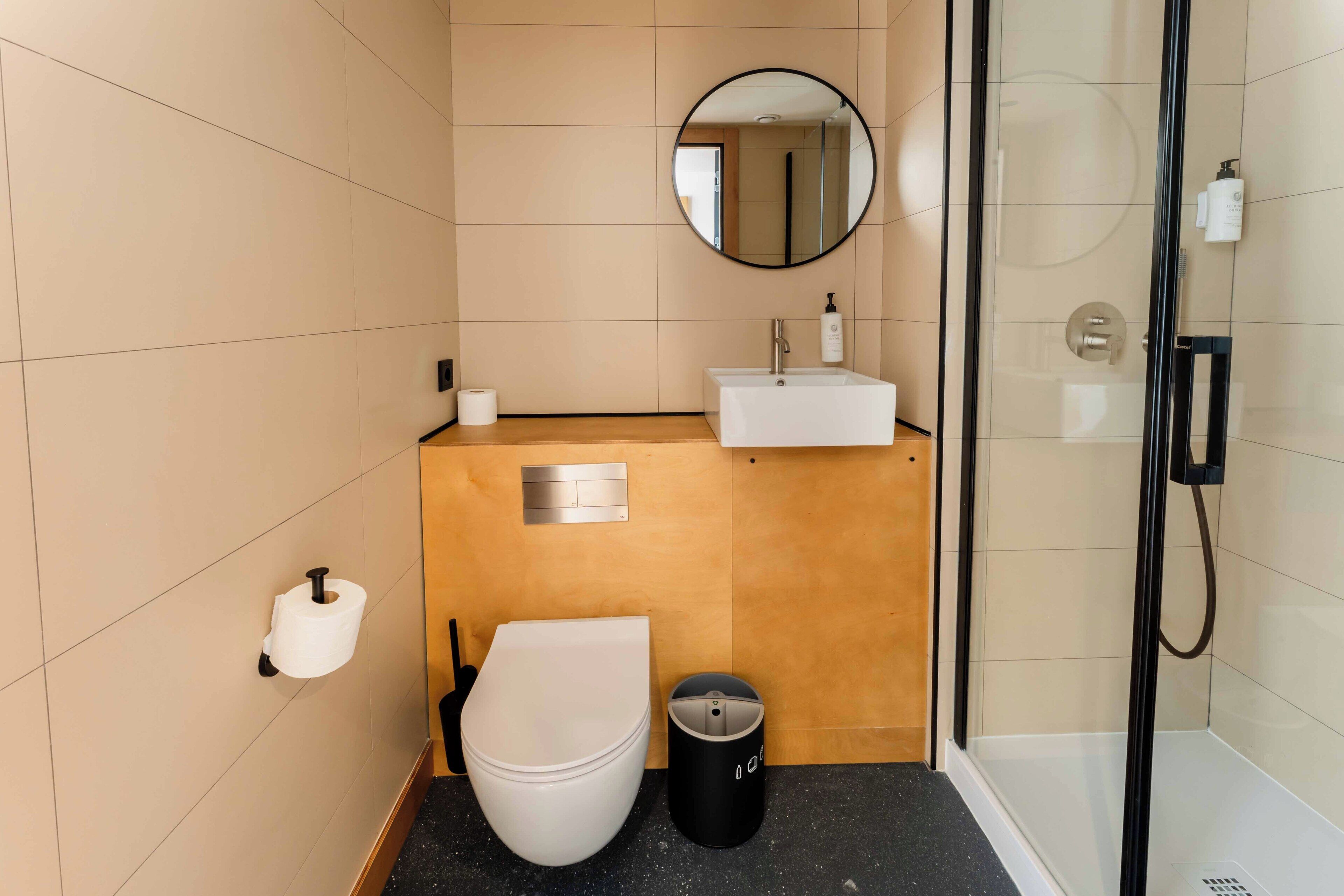 A modern bathroom with a toilet, sink, and shower.