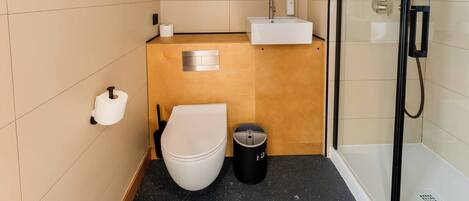 A modern bathroom with a toilet, sink, and shower.