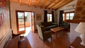 A spacious living room with a wooden ceiling, a sofa, a coffee table, and a lamp. - Son Marge Sl.l (Ses Salines)