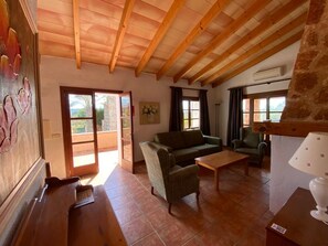 Ein geräumiges Wohnzimmer mit Holzboden, einem Sofa, einem Couchtisch und einer Lampe.