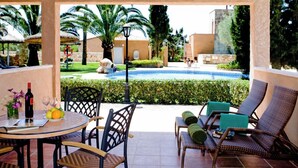 A covered outdoor area with a pool, lounge chairs, and a table with drinks and fruits. - Son Marge Sl.l (Ses Salines)