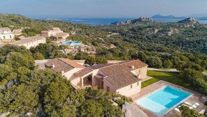 A villa with a swimming pool, surrounded by lush greenery and hills. - Hotel Borgo Smeraldo (Olbia)