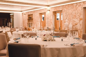 A banquet hall with round tables set for dining, featuring white tablecloths, candles, and floral centerpieces. - Hotel Borgo Smeraldo (Olbia)