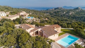 A villa with a swimming pool, surrounded by lush greenery and hills. - Hotel Borgo Smeraldo (Olbia)
