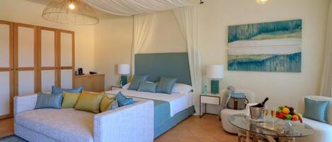 Una habitación de hotel moderna con cama, sofá y una mesa de centro de vidrio.