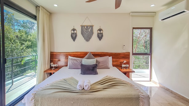 A spacious bedroom with a large bed, wooden headboard, and two bedside tables. - Luxury Boutique Hotel Villas Jardin Caracol Tulum (Tulum)