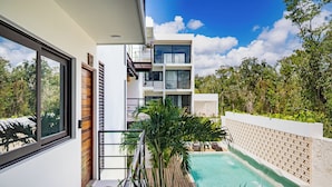 A modern building with a pool, balconies, and lush greenery. - Luxury Boutique Hotel Villas Jardin Caracol Tulum (Tulum)