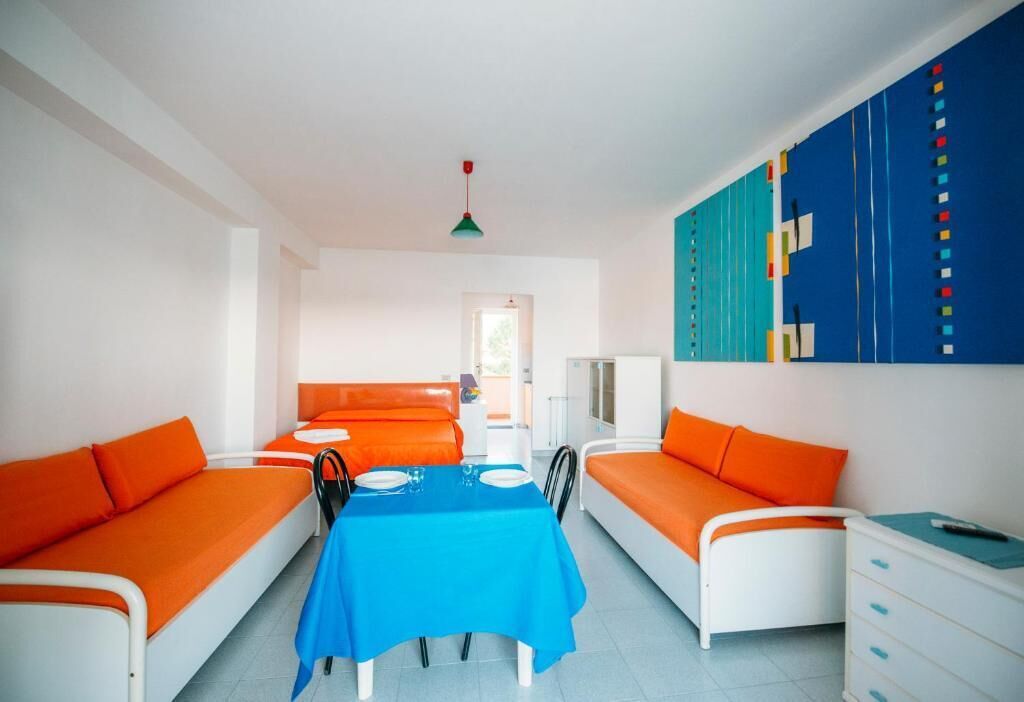 Una stanza con due letti, un tavolo da pranzo e una tovaglia blu.