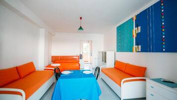Ein Zimmer mit zwei Betten, einem Esstisch und einer blauen Tischdecke.