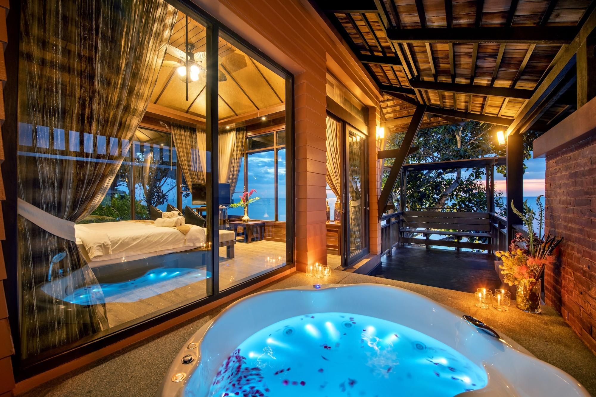 Un dormitorio lujoso con una cama grande, una ventana con cerramiento de vidrio y un jacuzzi.