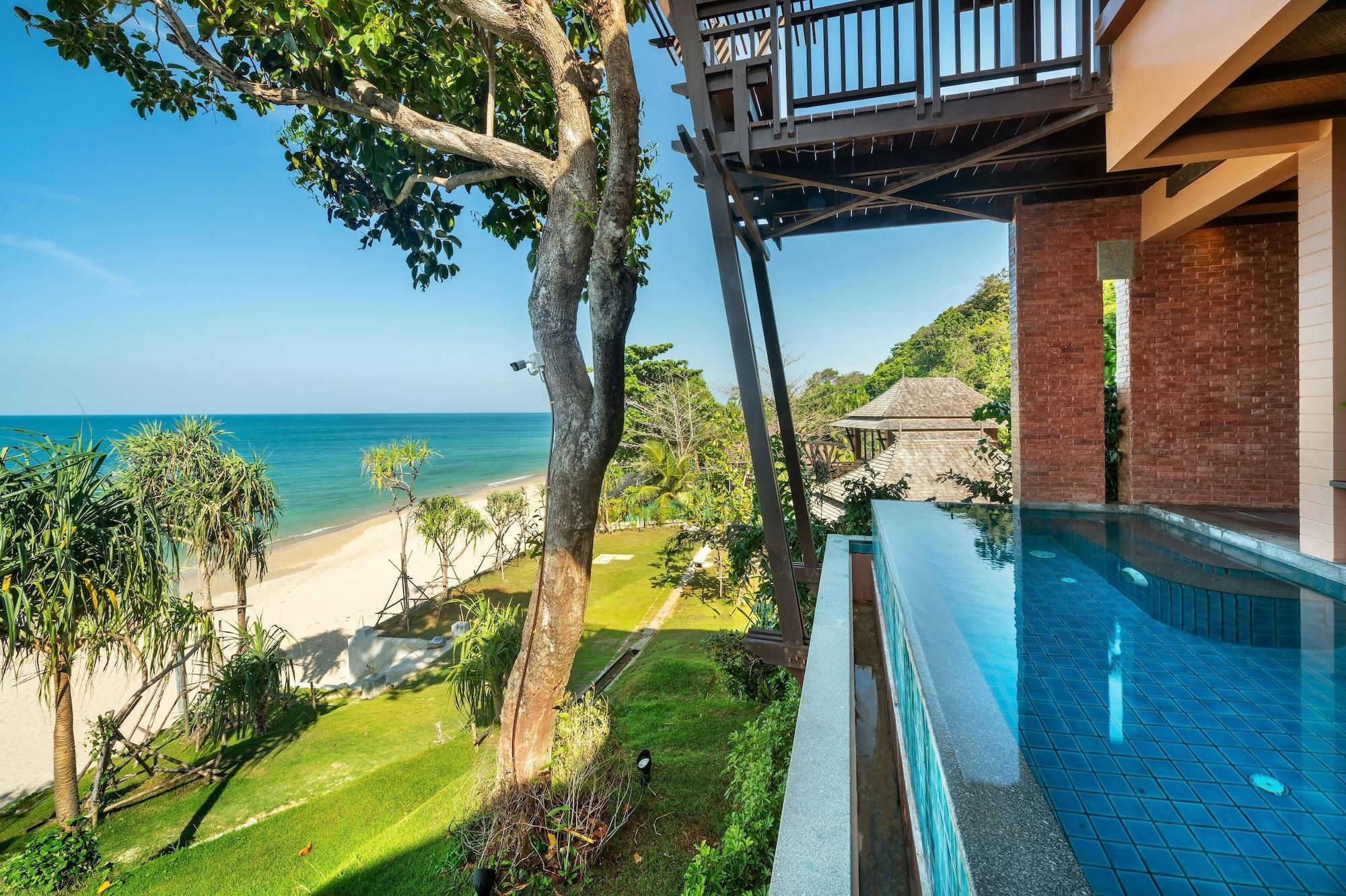 A pool area with a view of the beach and ocean.