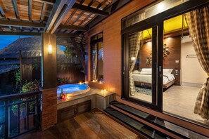 A modern bedroom with a large window, a hot tub, and a balcony with wooden flooring. - Nirvana Beach Resort (Ko Lanta)