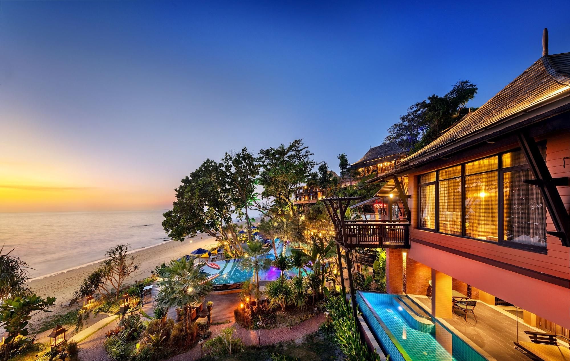 Un resort con piscina, vista al mar y zona de estar al aire libre.