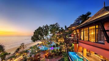 Un resort con piscina, vista al mar y zona de estar al aire libre.