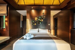 A modern hotel room with a large bed, wooden panel walls, a decorative wall piece, and a window with blinds. - Nirvana Beach Resort (Ko Lanta)