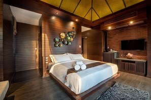 A modern bedroom with a large bed, a wall-mounted TV, and a decorative wall piece. - Nirvana Beach Resort (Ko Lanta)