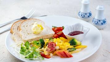 Un plato con huevos revueltos, verduras y tostadas con mantequilla.