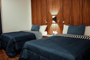 A hotel room with two beds, wooden headboard, and bedside tables with lamps. - Sky Inn Hotel (Cancun)