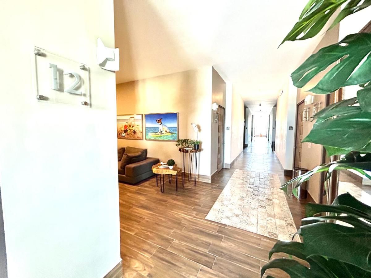 A hallway with a wooden floor, a sofa, a coffee table, and a painting on the wall.