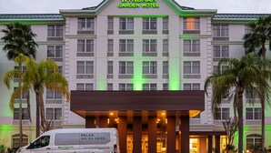 The Wyndham Garden Hotel with a modern facade, large windows, and a van parked in front.