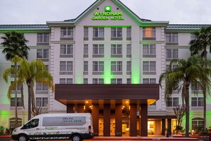 Das Wyndham Garden Hotel mit moderner Fassade, großen Fenstern und einem Lieferwagen vor dem Haus.