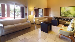 A spacious lobby with a beige sofa, a coffee table, and a patterned bench.