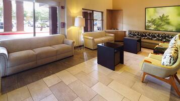 A spacious lobby with a beige sofa, a coffee table, and a patterned bench.