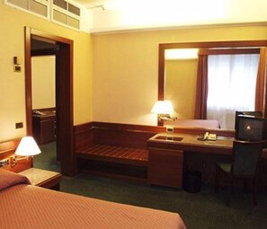 A hotel room with a bed, a desk, a chair, a mirror, and a television. - Hotel Crivi's (Milan)