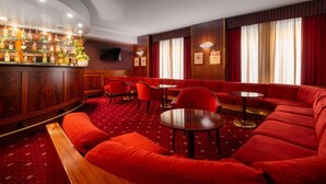 A bar area with a red carpet, wooden paneling, and red upholstered seating. - Hotel Crivi's (Milan)