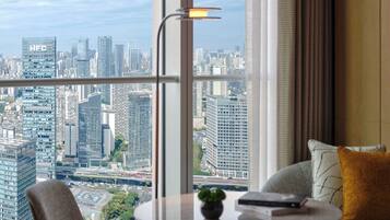 A modern room with a city view, a round table, a chair, and a sofa.