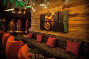 A modern lounge area with a tufted sofa, orange chairs, and pendant lighting. - Azul Beach Resort Negril By Karisma (Negril)