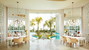 A spacious indoor area with a pool view, featuring two workstations with computers, white furniture, and a modern ceiling design. - Azul Beach Resort Negril By Karisma (Negril)