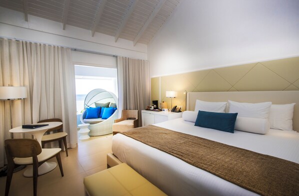 Une chambre d’hôtel avec un grand lit, un bureau, une chaise et un canapé.